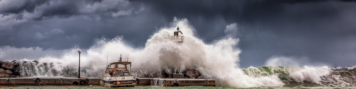 Ola rompiendo sobre rompeolas