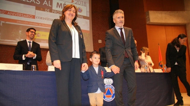 Grande-Marlaska con el niño de cuatro años Luca Álvarez Toribio condecorado con la medalla al Mérito de Protección Civil 2018