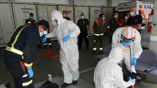 varias personas enseñan en el curso como ponerse los trajes de protección